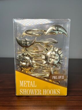 A set of 12 gold-toned metal shower curtain hooks with sun, stars and moon.